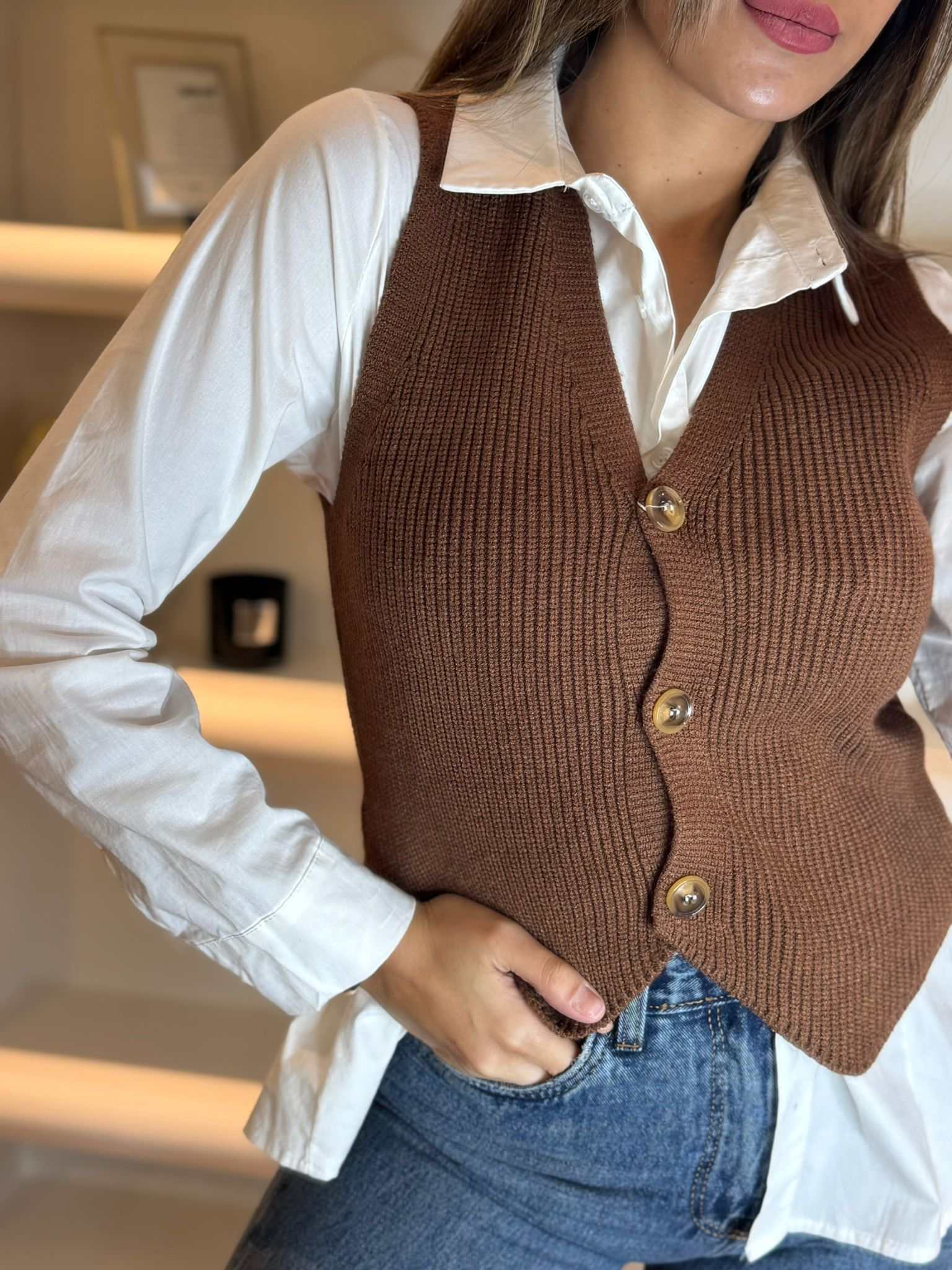 Women’s brown knit button-front vest layered over a white shirt